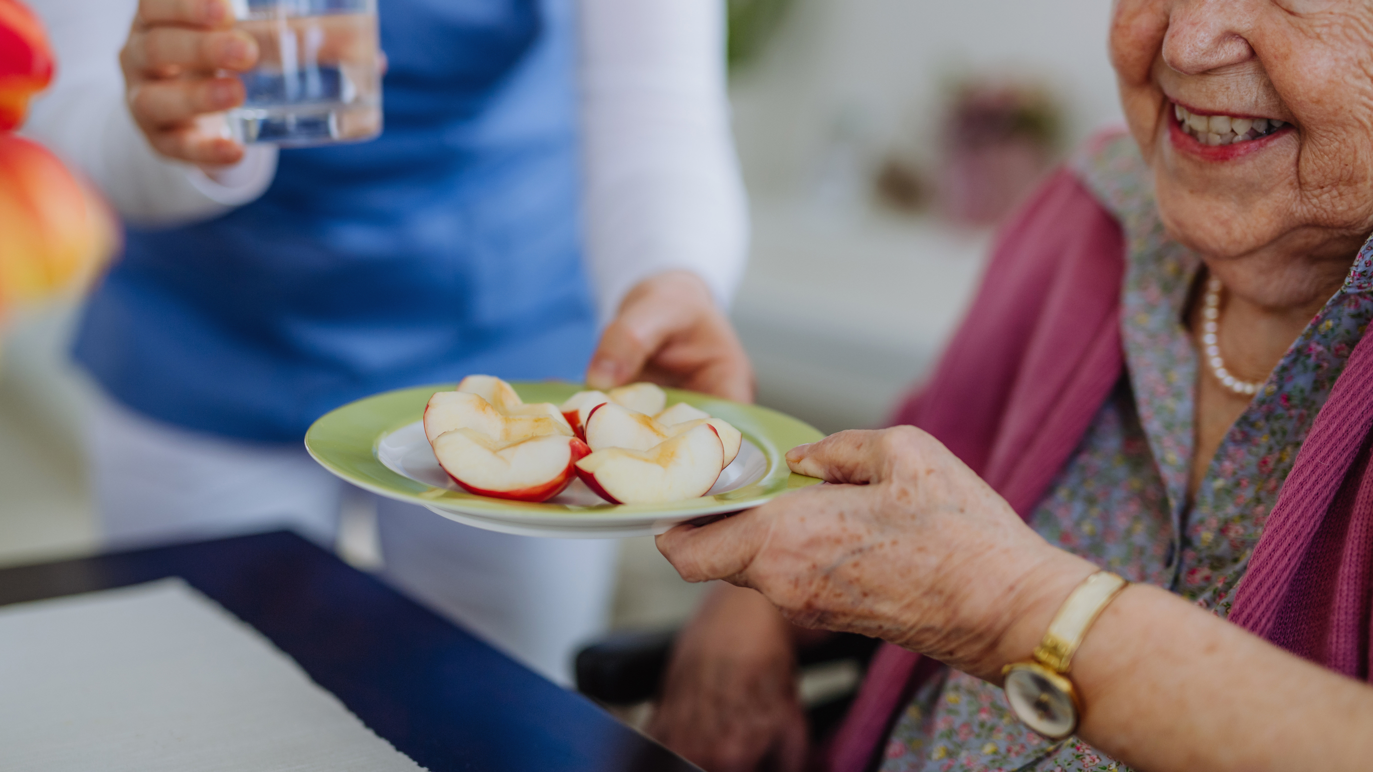 Pflegerin gibt Seniorin essen