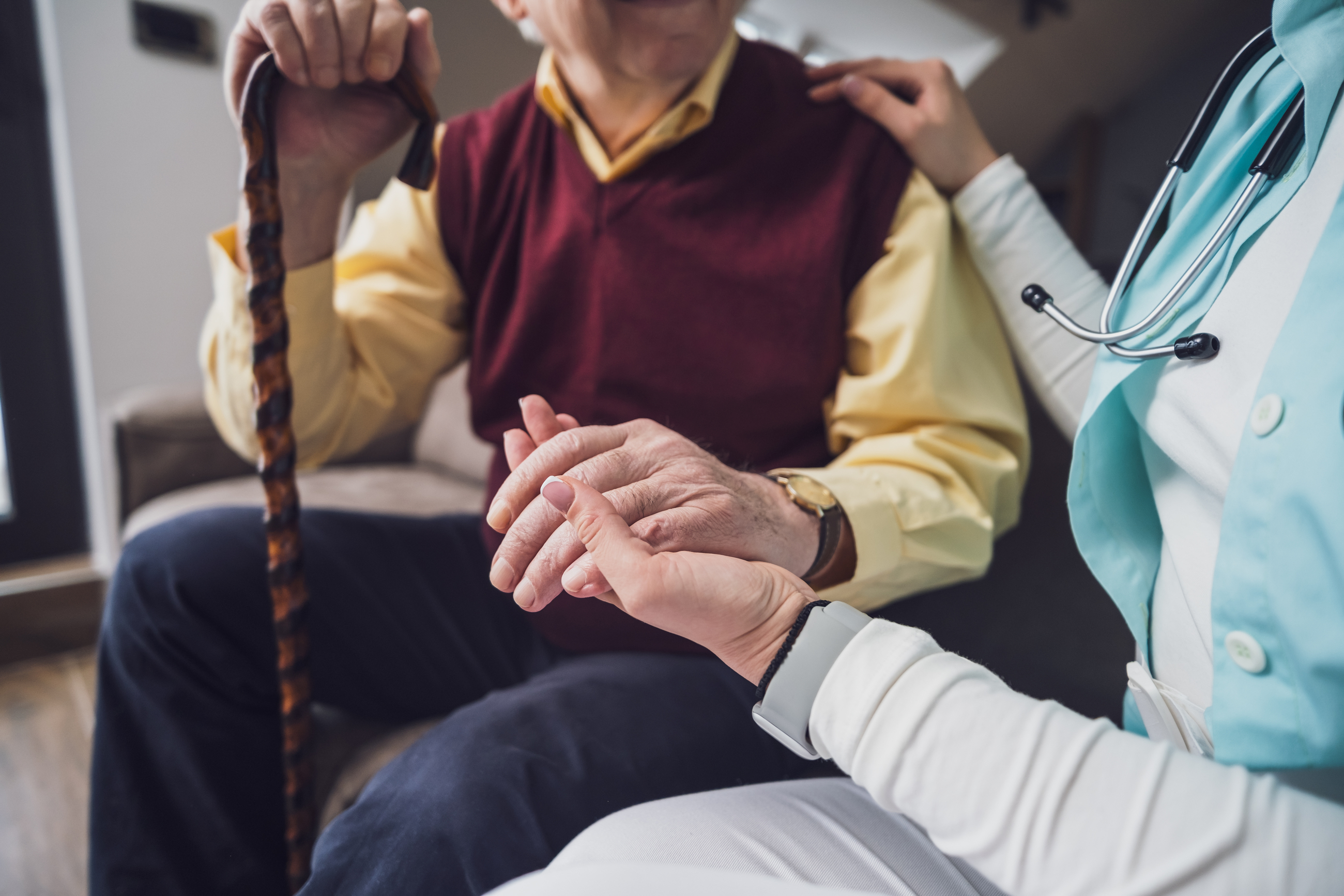 Senior hält Hand von Pflegerin